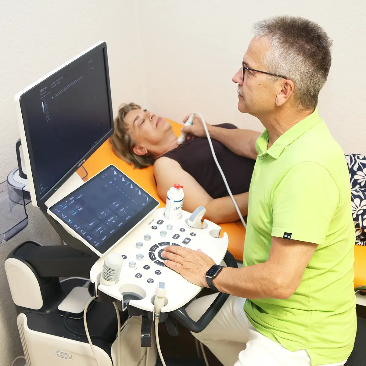Hausarzt macht eine Ultraschall-Untersuchung bei einer Patientin
